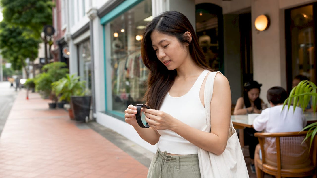 Woman examining wearable fitness tracker in Singapore store